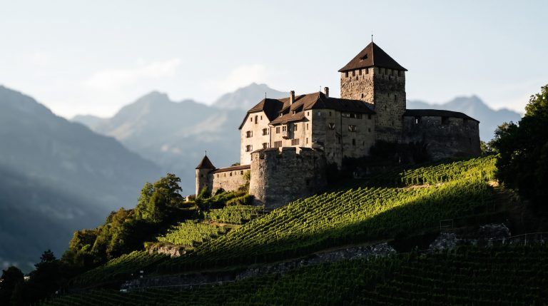 Vaduz Castle on a hillside above the capital of Liechtenstein with Alps behind