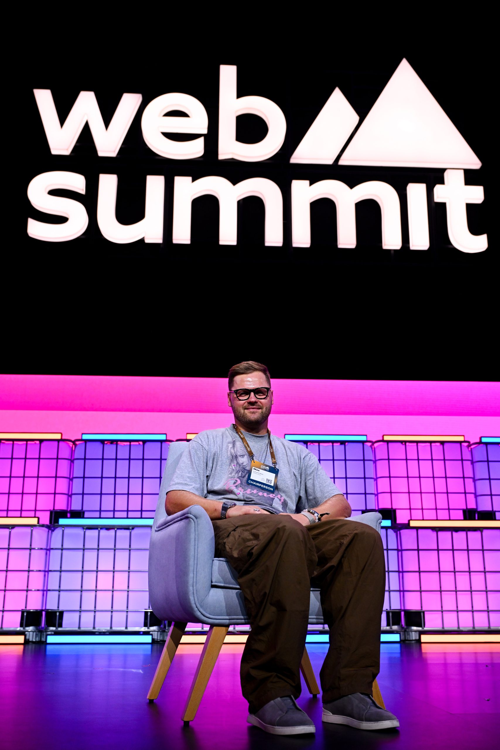 Wide view of the Web Summit Qatar venue in Doha with a large audience of attendees seated and standing, watching a presentation on stage, representing the scale and energy of the global tech conference.