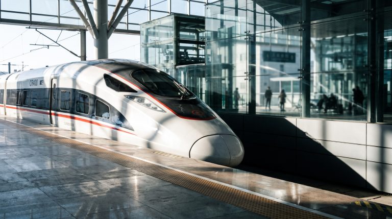 Chinese high-speed bullet train at a modern glass station platform