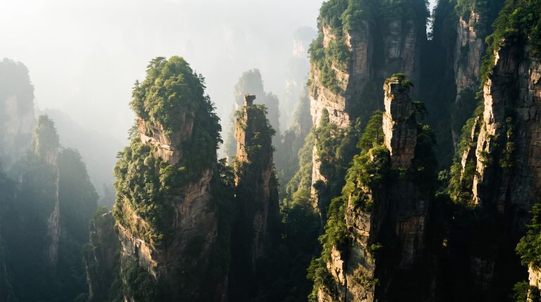 Zhangjiajie sandstone pillar mountains rising through mist at sunrise in China