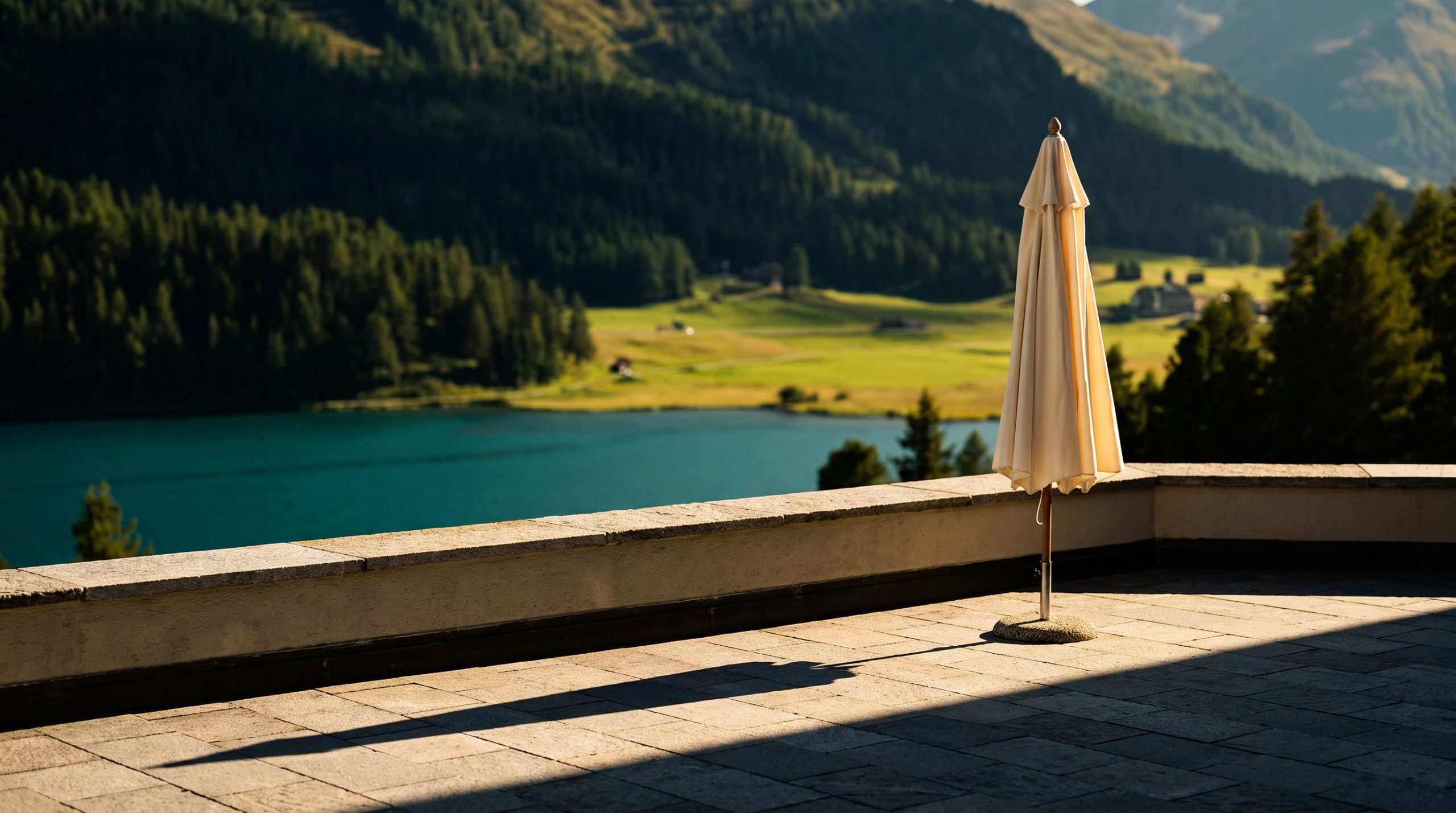 Alpine luxury hotel terrace overlooking Lake St. Moritz in summer