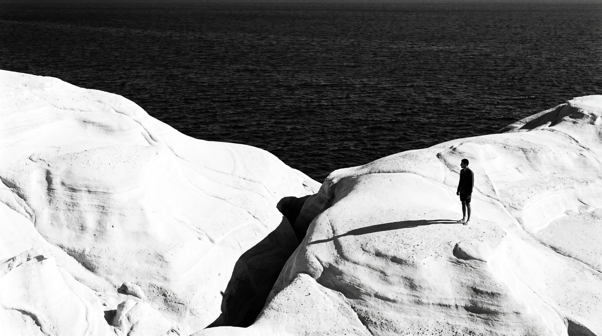 White volcanic moonscape rocks of Sarakiniko beach on Milos meeting blue sea