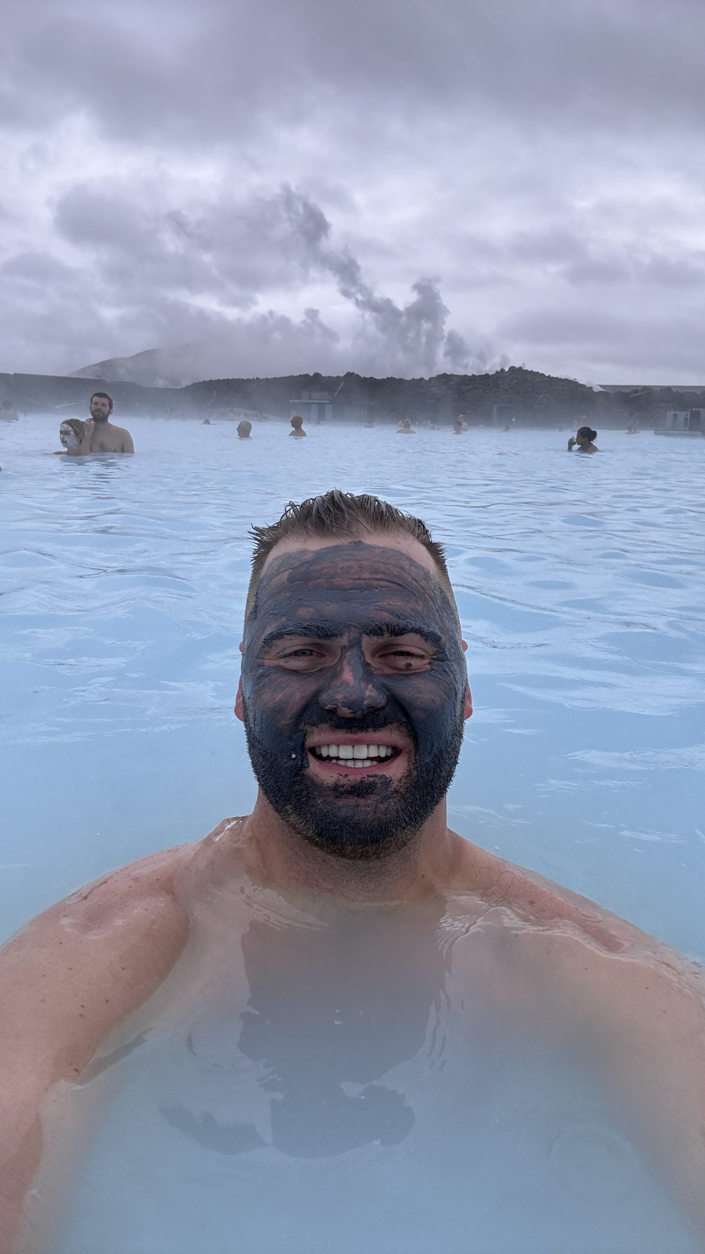 Max Zaharenkov in the Blue Lagoon geothermal spa with a silica mud mask, steam rising behind