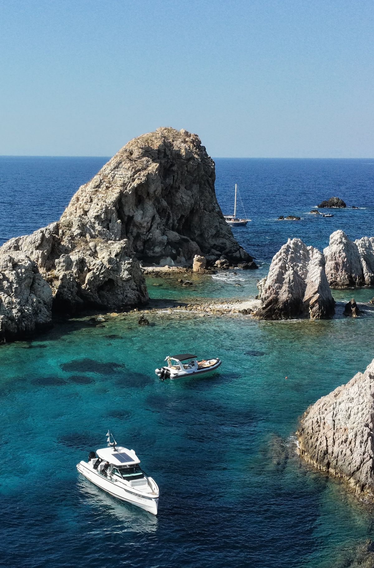 Rocky islets and boats anchored in turquoise water on the Antiparos day trip